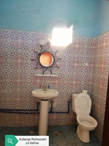 a bathroom with a toilet and a sink and a light at Auberge Restaurant le Safran in Taliouine
