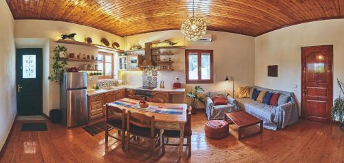 cocina y sala de estar con mesa y sofá en The Guund House, en Xanthátai