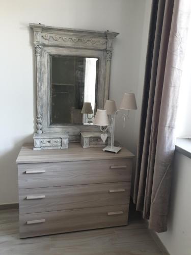 a dresser with two lamps and a mirror on it at Civico36 in Passignano sul Trasimeno