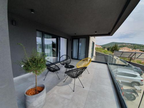 a patio with chairs and a table on a balcony at Residence Alpha Apartments in Cavtat