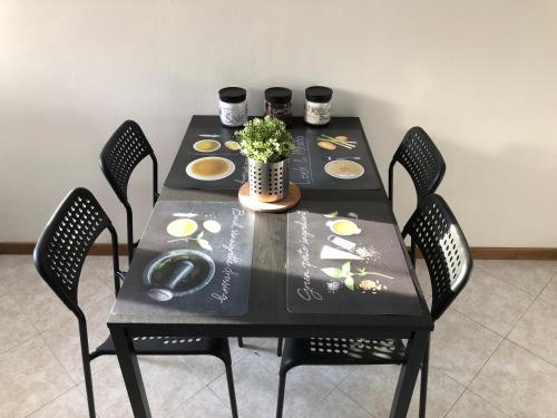 a black table with chairs and a table with plates and flowers at La Terrazza di Beppe in Negrar