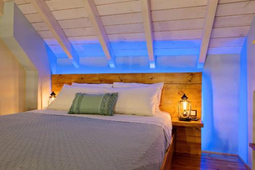 a bedroom with a bed with a blue ceiling at Archontissa House in the Old Town in Rethymno