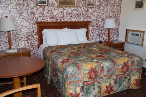 a hotel room with a bed and a table at Sara Glen Motel - Saratoga Springs-Glens Falls in Saratoga Springs