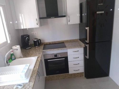 甘迪亞的住宿－Apartamento "Pedro" 250 m de la playa，厨房配有黑色冰箱和水槽