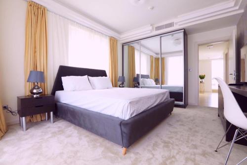 Schlafzimmer mit einem Bett, einem Schreibtisch und einem Spiegel in der Unterkunft 33rd floor luxury apartment spa & fitness in Skopje
