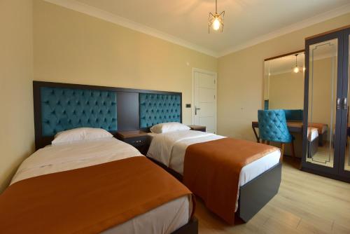 um quarto de hotel com duas camas e uma cadeira em İnanlar Airport Residence em Trabzon