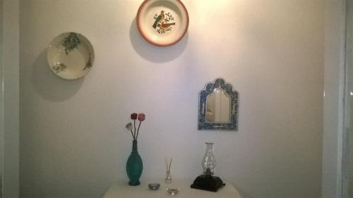 a shelf with vases and a mirror on a wall at The Aqueduct Guesthouse in Évora