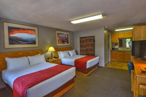 a hotel room with two beds and a flat screen tv at Rustic Inn in Moab