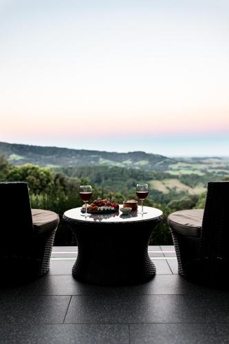 a table with two glasses of wine and food on it at Mt Hay Retreat in Berry