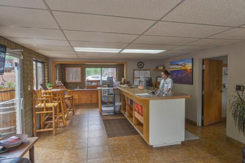 a woman is sitting at a counter in a room at Rustic Inn in Moab