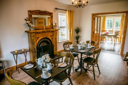 uma sala de jantar com mesas e uma lareira em Farmleigh House, em Donegal