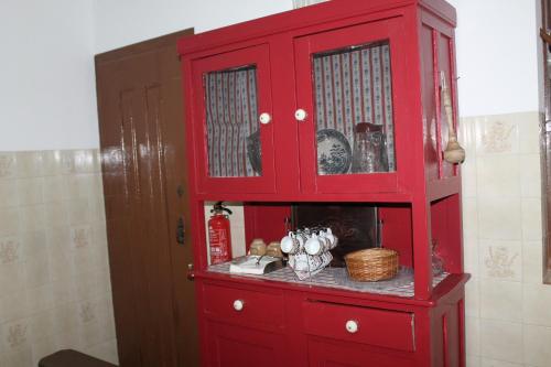 a red cabinet in the corner of a room at Casa dos Tios Estremoz-veiros in Veiros