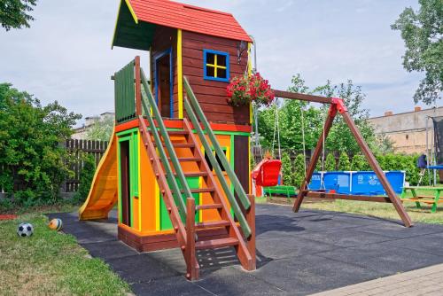 a playground with a play house and a slide at RIGAAPARTMENT SONADA Family Aparthotel - Private Parking in Rīga