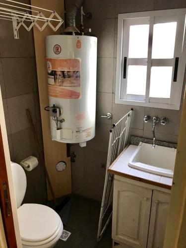 a bathroom with a toilet and a sink and a window at El Remanso de Colón in Colón