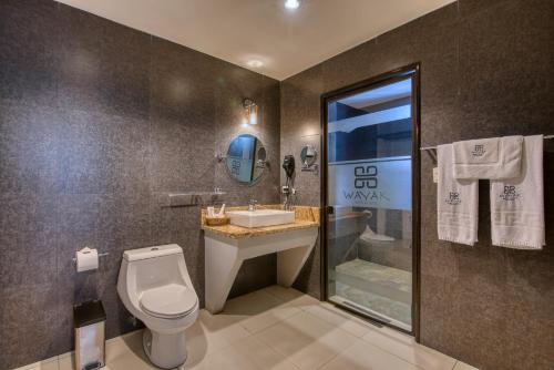 a bathroom with a toilet and a sink at Wayak Hotel in Managua