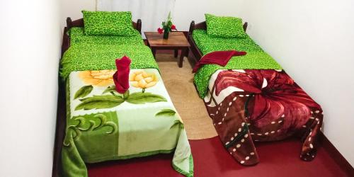two beds sitting next to each other in a room at Shimbwe Meadows Guest House in Moshi