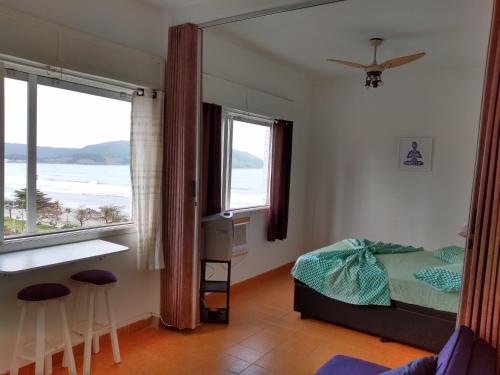 桑托斯Apto Frente a Praia em Santos的一间卧室，配有一张床、一张书桌和一扇窗户