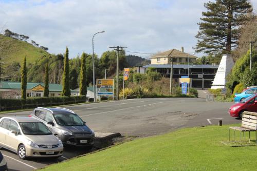 a parking lot with cars parked in front of a building at Waitomo Caves Guest Lodge in Waitomo Caves