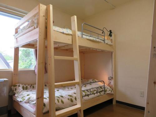 a bedroom with two bunk beds in a room at Guesthouse Sakamichi Sampo in Kushiro