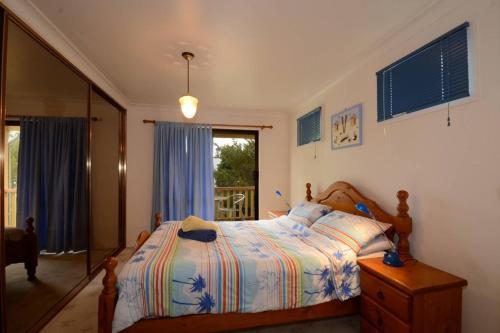 a bedroom with a bed and a window at Seahaven Beach House - Shellharbour in Shellharbour