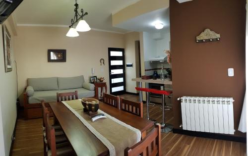 sala de estar con mesa, sofá y cocina en Departamento zona céntrica (Caseros) en Salta