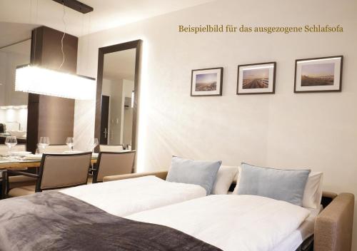 a bedroom with two beds and a dining room at White Pearl Apartment 1.03 in Timmendorfer Strand