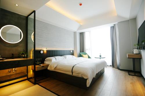 A bed or beds in a room at Hangzhou Yuqi Hotel - West Lake Leifeng Tower Branch