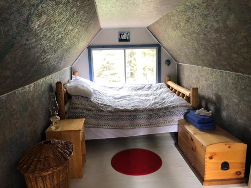 Jade City的住宿－Vines and Puppies Hideaway，小型阁楼卧室设有1张床和1扇窗户。