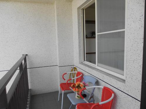 a balcony with two chairs and a table and a window at 蘭卡威羅東庭園民宿 in Luodong