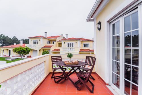 a patio with two chairs and a table on a balcony at Burgo Dom Afonso V Golf & Beach Resort in Casal da Lagoa Seca