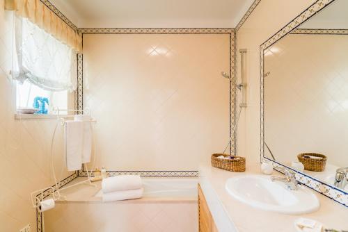 a bathroom with a sink and a mirror at Burgo Dom Afonso V Golf & Beach Resort in Casal da Lagoa Seca