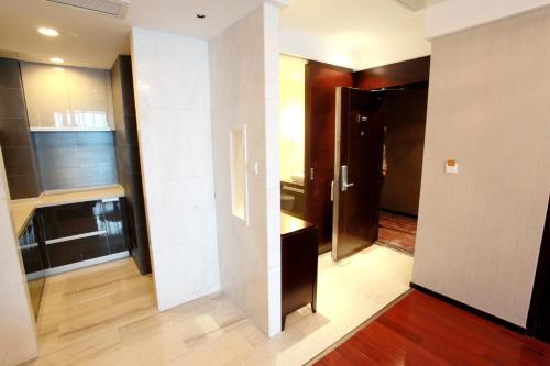 een kamer met een deur naar een keuken bij The Cumberland Boutique Hotel in Nanjing