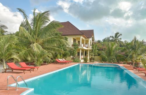 una piscina del resort con sedie e palme di Ifa Beach Resort a Jambiani