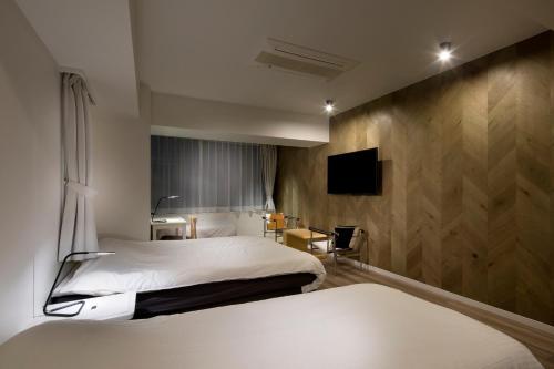 Tempat tidur dalam kamar di Shinjuku City Hotel N.U.T.S Tokyo