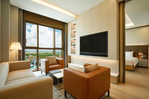 a hotel room with a television and a living room at Shinhwa Jeju Shinhwa World Hotels in Seogwipo