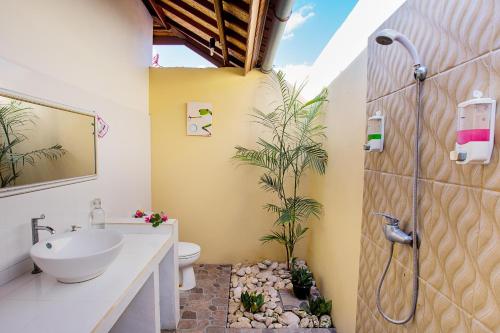 La salle de bains est pourvue d'un lavabo, de toilettes et d'une douche. dans l'établissement Nusa Veranda Sunset Villas & Restaurant, à Nusa Lembongan