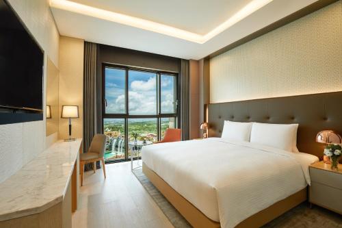 a hotel room with a bed and a large window at Shinhwa Jeju Shinhwa World Hotels in Seogwipo