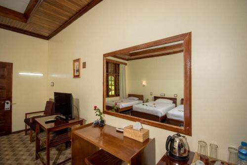 a room with a mirror and a desk and a bed at Ruby True Hotel in Bagan