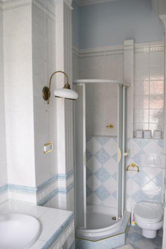 a bathroom with a shower and a sink and a toilet at Taverna panzió in Sopron