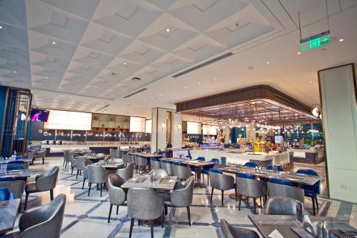 a restaurant with tables and chairs and a bar at Wyndham Qingdao l Free Fixed-Time Shuttle Service Between Hotel and Airport & North Railway Station l Outdoor Children's Amusement Park l 1-Hour Play Snooker or Table Tennis in Qingdao