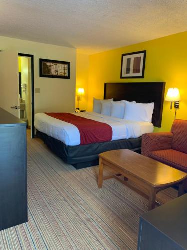 a hotel room with a large bed and a table at Americas Best Value Inn - Fredericksburg North in Fredericksburg