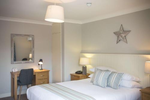 a bedroom with a bed and a desk with a star on the wall at George Hotel, BW Signature Collection in Norwich