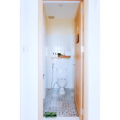 a bathroom with a white toilet in a room at NẮNG House in Da Nang