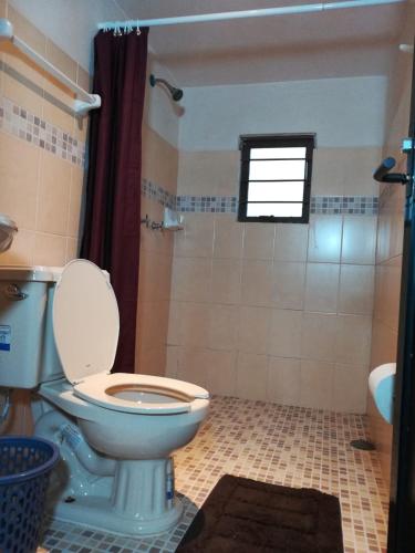 a bathroom with a toilet and a shower with a window at Cabaña El Salto in Cuetzalán del Progreso