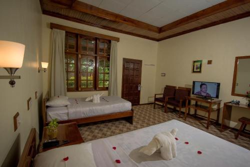 a hotel room with a bed and a television at Ruby True Hotel in Bagan