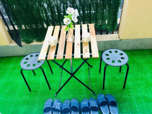 a wooden bench with two chairs and a table with flowers at 板橋 RCアネックス Rc208 in Tokyo