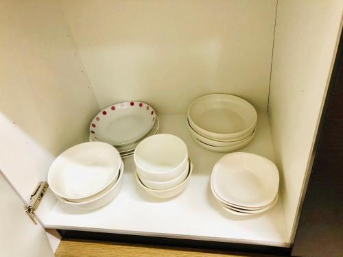 four white bowls sitting on a shelf in a drawer at 板橋 RCアネックス Rc208 in Tokyo