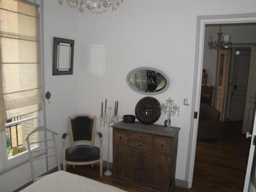una stanza con specchio, cassettiera e sedia di Almeria Garden Apartment a Parigi