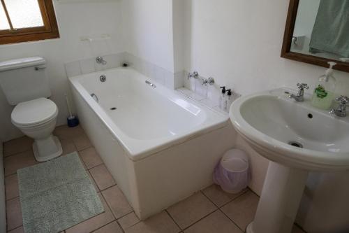 艾伯特王子镇Acacia Cottage的带浴缸、马桶和水槽的浴室