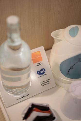 a bottle of water on a box next to a vase at Malaka Hotel Bandung in Bandung